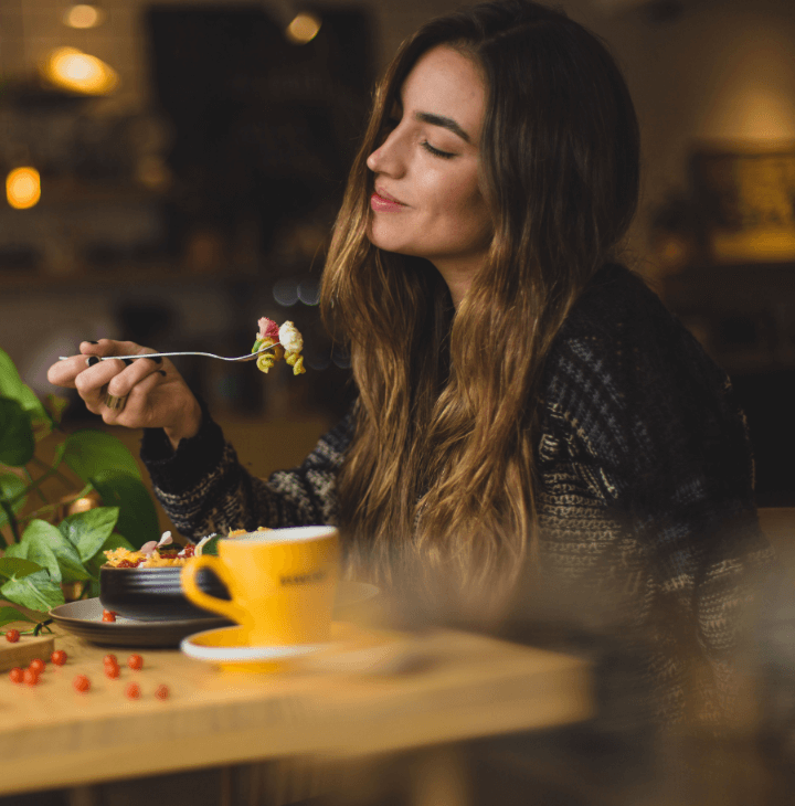 A woman enjoying a bowl of pasta